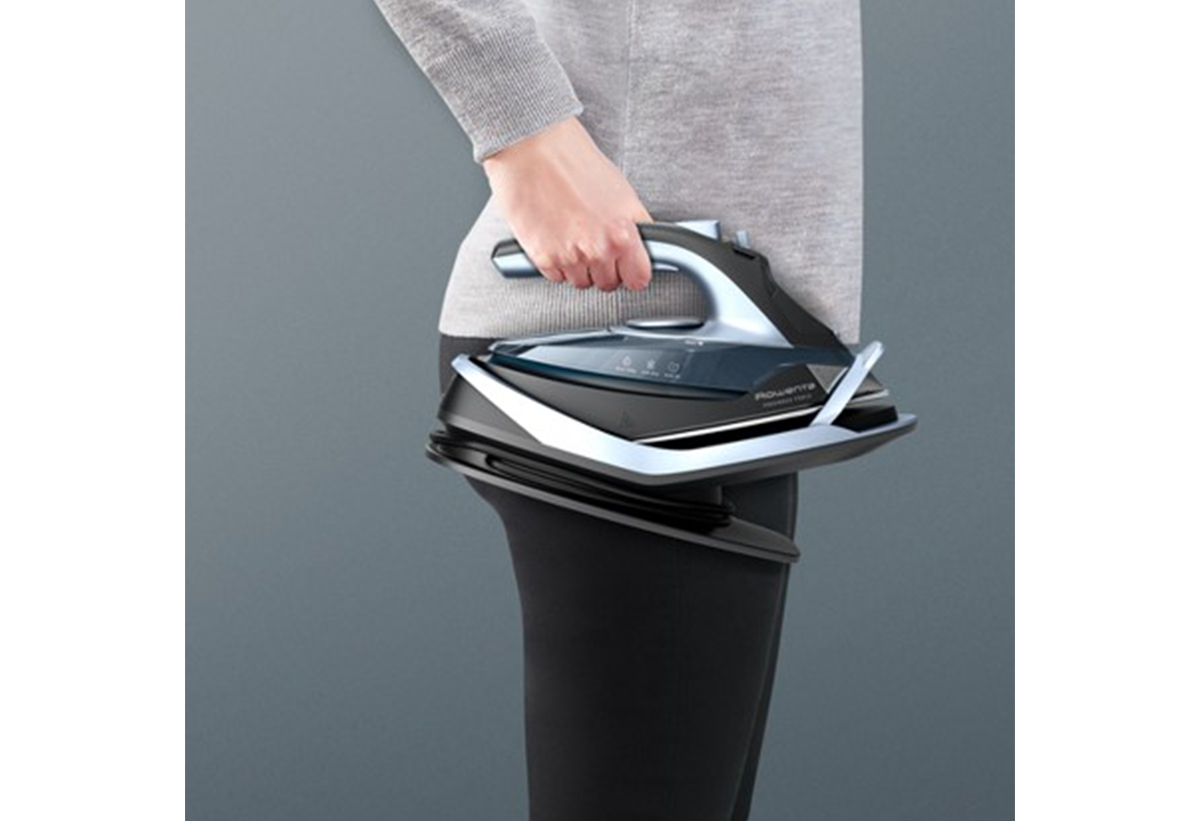 Απεικονίζεται μια γυναίκα να να κρατά εύκολα στο ένα της χέρι το σίδερο με τη βάση του.